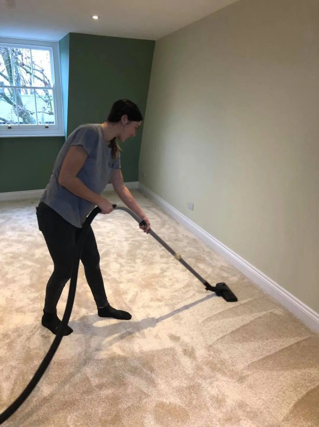 Elite cleaner vacuuming a carpet in a Cambridge home