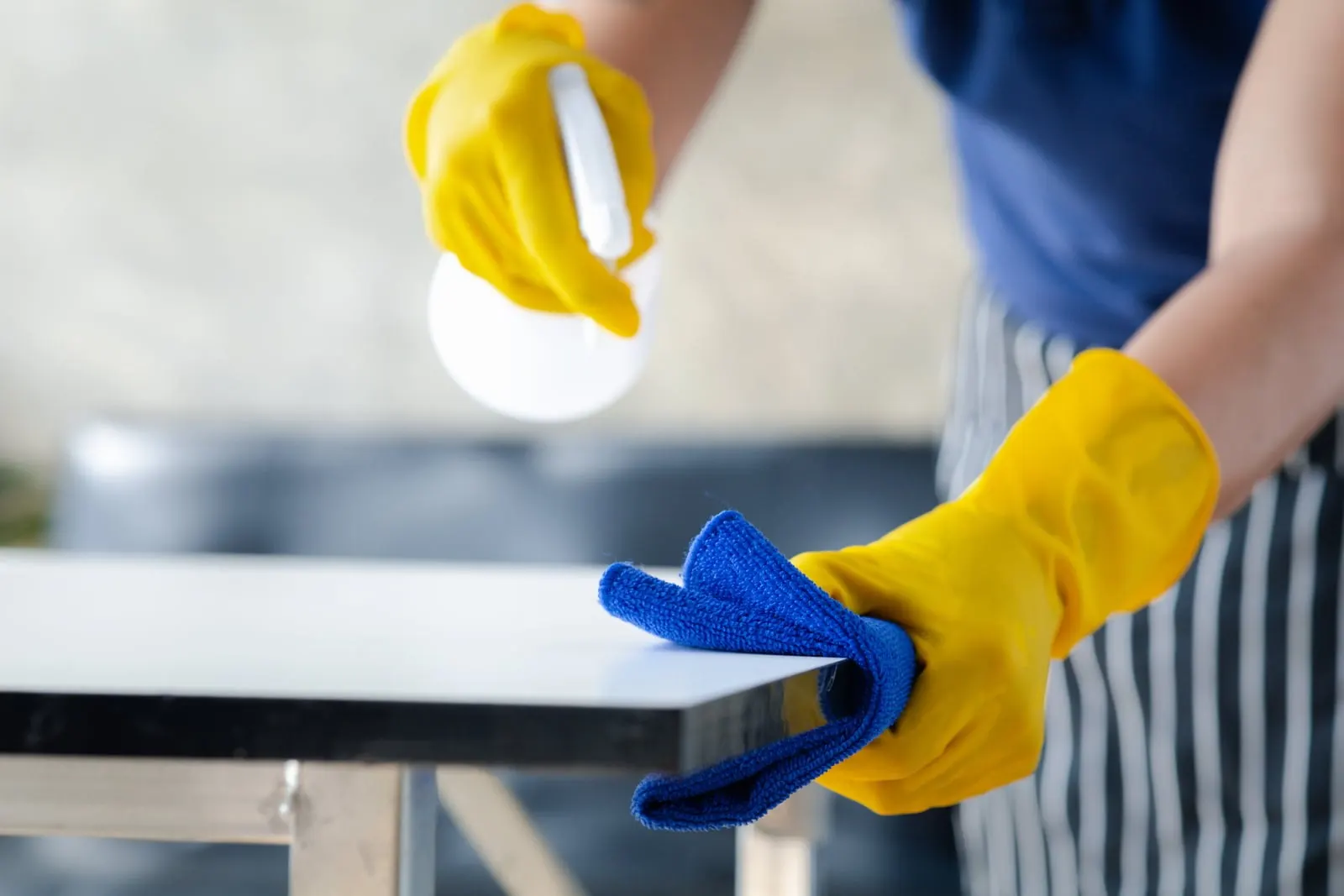 Cleaner wiping down a worktop - Elite Cleaning Services Cambridge